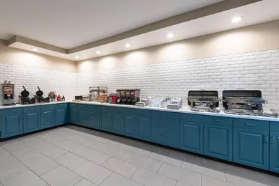 a large kitchen with blue cabinets and white bricks at Country Inn & Suites by Radisson, Findlay, OH in Findlay