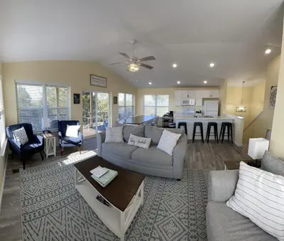 a living room with a couch and a table and a kitchen at 100 Acre Relaxing Retreat Near ARK- The Farmhouse in Williamstown