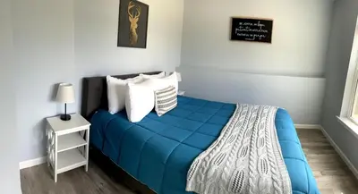 a bedroom with a blue bed with white pillows at 100 Acre Relaxing Retreat Near ARK- The Woodlands in Williamstown