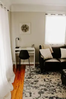 a living room with a couch and a desk at Cozy house near Lake Erie, 10 minutes to Downtown. in Cleveland