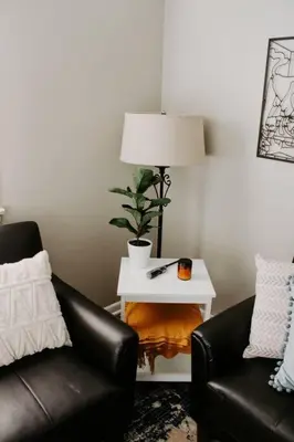 a living room with two leather chairs and a table with a lamp at Cozy house near Lake Erie, 10 minutes to Downtown. in Cleveland