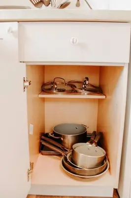 a kitchen with two pots and pans in a cabinet at Cozy house near Lake Erie, 10 minutes to Downtown. in Cleveland
