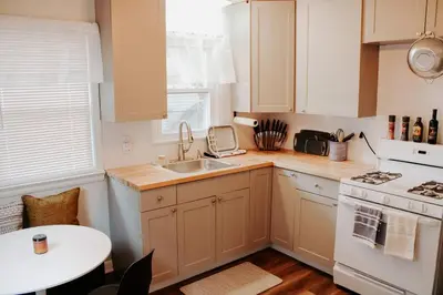 a kitchen with white cabinets and a sink and a stove at Cozy house near Lake Erie, 10 minutes to Downtown. in Cleveland