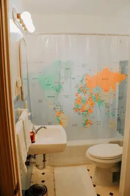 a bathroom with a map of the world shower curtain at Cozy house near Lake Erie, 10 minutes to Downtown. in Cleveland