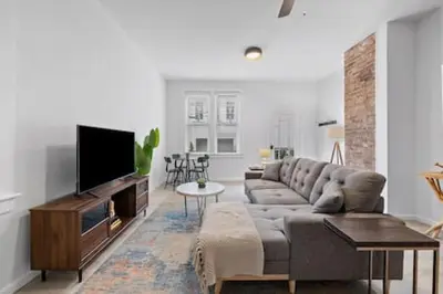 a living room with a couch and a flat screen tv at Charming Mt. Adams 1BR - Near Downtown & Stadiums in Cincinnati