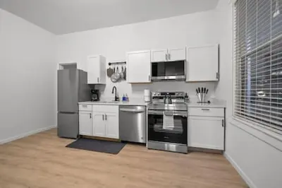 a kitchen with white cabinets and stainless steel appliances at Charming Mt. Adams 1BR - Near Downtown & Stadiums in Cincinnati