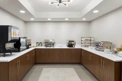 a large kitchen with wooden cabinets and a ceiling at Wingate Suites By Wyndham Mansfield Ontario in Mansfield