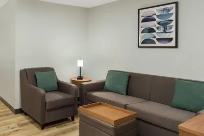 a living room with a couch and two chairs at Wingate Suites By Wyndham Mansfield Ontario in Mansfield