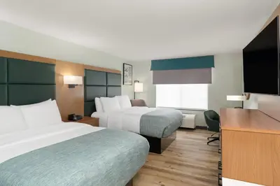 a hotel room with two beds and a flat screen tv at Wingate Suites By Wyndham Mansfield Ontario in Mansfield