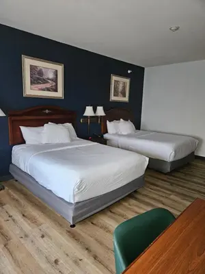 a hotel room with two beds and a table at Wingate Suites by Wyndham Youngstown - Austintown in Youngstown