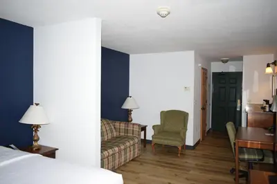 a hotel room with a bed and a couch and a desk at Wingate Suites by Wyndham Youngstown - Austintown in Youngstown