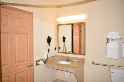 a bathroom with a sink and a phone on the wall at Wingate Suites by Wyndham Youngstown - Austintown in Youngstown