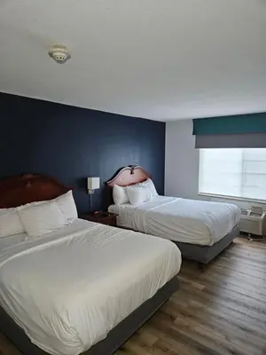 a hotel room with two beds and a blue wall at Wingate Suites by Wyndham Youngstown - Austintown in Youngstown
