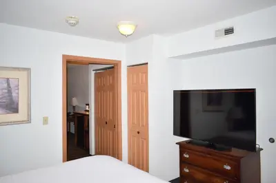 a bedroom with a bed and a flat screen tv at Wingate Suites by Wyndham Youngstown - Austintown in Youngstown