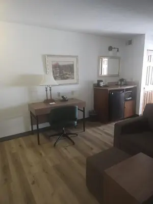 a living room with a desk and a chair at Wingate Suites by Wyndham Youngstown - Austintown in Youngstown