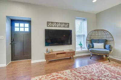 a living room with a chair and a tv at Historic Loveland Apt Walk to Little Miami River! in Loveland