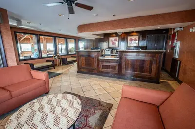 a living room with red furniture and a kitchen at Christopher Inn and Suites in Chillicothe