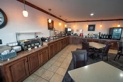 a restaurant with a counter and tables and chairs at Christopher Inn and Suites in Chillicothe
