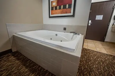 a bath tub in a bathroom with a tile floor at Christopher Inn and Suites in Chillicothe