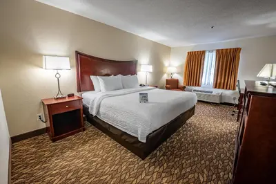a hotel room with a large bed and a window at Christopher Inn and Suites in Chillicothe