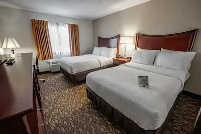 a hotel room with two beds and two windows at Christopher Inn and Suites in Chillicothe