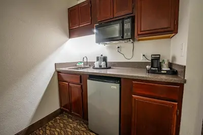 a small kitchen with a sink and a microwave at Christopher Inn and Suites in Chillicothe