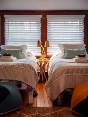 two beds in a room with two windows at 19th Century 'Cleveland Double' - Walk To Beach in Cleveland