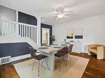 a living room with a dining room table and chairs at 19th Century 'Cleveland Double' - Walk To Beach in Cleveland