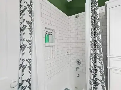 a bathroom with a shower with a black and white shower curtain at 19th Century 'Cleveland Double' - Walk To Beach in Cleveland