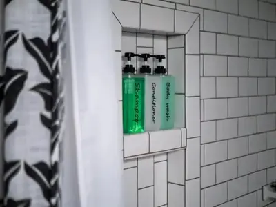 a green bottle of toothpaste in a bathroom mirror at 19th Century 'Cleveland Double' - Walk To Beach in Cleveland