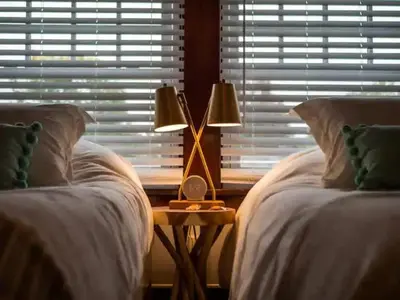 a bedroom with two beds and a table with a lamp at 19th Century 'Cleveland Double' - Walk To Beach in Cleveland