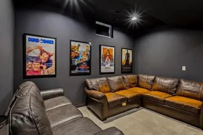 a living room with a leather couch and posters at Luxuary Tremont Home - Movie Room, Pet & Baby Friendly in Cleveland