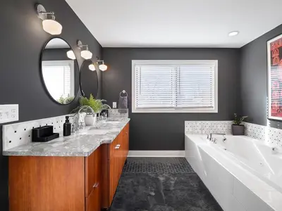 a bathroom with a tub and a sink and a mirror at The Emerald Manor in Cleveland