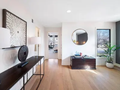 a living room with a table and a mirror at The Emerald Manor in Cleveland