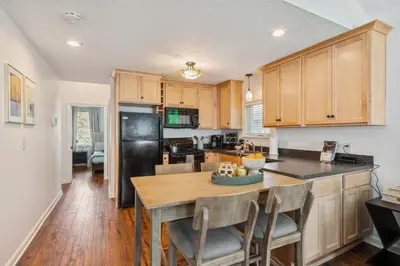 a kitchen with a wooden table and a black refrigerator at Newly Renovated Tremont Treasure I Cozy + Modern in Cleveland