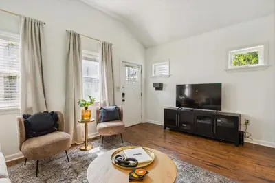 a living room with a television and two chairs at Newly Renovated Tremont Treasure I Cozy + Modern in Cleveland