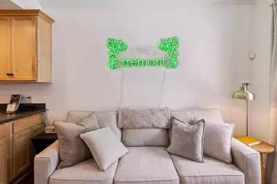 a living room with a couch and a sign on the wall at Newly Renovated Tremont Treasure I Cozy + Modern in Cleveland