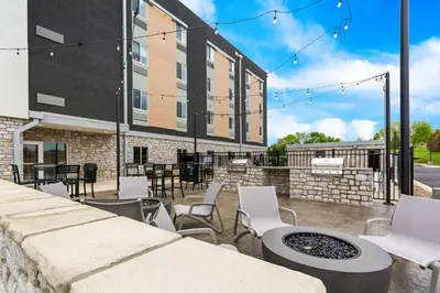 a patio with chairs and a fire pit in front of a building at Everhome Suites Lexington - Horse Park in Lexington