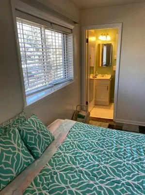 a bedroom with a bed and a window and a bathroom at Lovely home away from home 4BR 3ba in Cincinnati