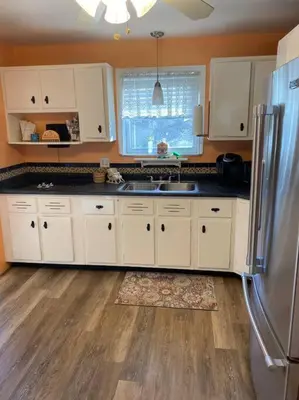 a kitchen with white cabinets and a stainless steel refrigerator at Lovely home away from home 4BR 3ba in Cincinnati