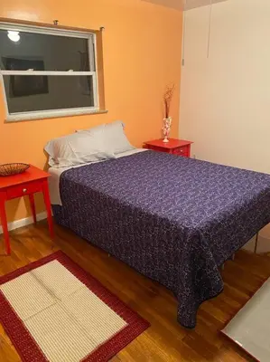 a bedroom with a bed with two tables and a window at Lovely home away from home 4BR 3ba in Cincinnati