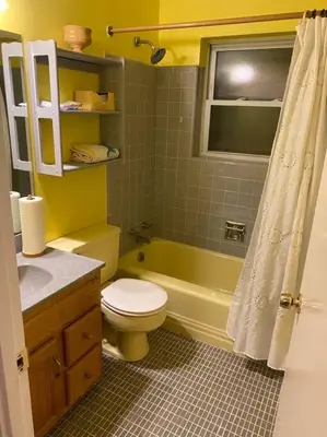 a yellow bathroom with a toilet and a sink at Lovely home away from home 4BR 3ba in Cincinnati