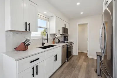 a kitchen with white cabinets and a refrigerator at Tranquil Pet Friendly Retreat residence in Reynoldsburg