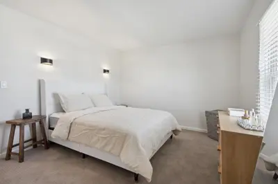 a white bedroom with a bed and a table at Tranquil Pet Friendly Retreat residence in Reynoldsburg