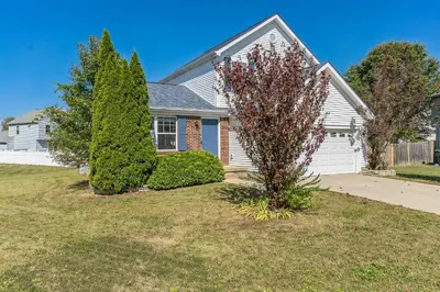 a house with two trees in the front yard at Tranquil Pet Friendly Retreat residence in Reynoldsburg