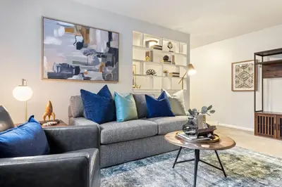 a living room with a gray couch and blue pillows at Maple Heights Haven - Unit 4 in Maple Heights