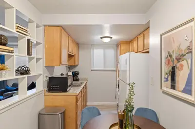 a kitchen with a table and a white refrigerator at Maple Heights Haven - Unit 4 in Maple Heights