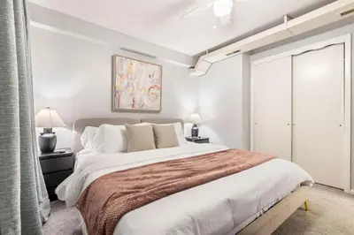 a white bedroom with a large bed and two lamps at Maple Heights Haven - Unit 4 in Maple Heights