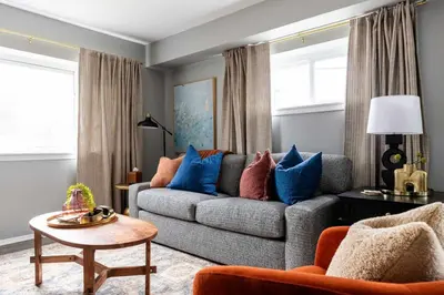 a living room with a gray couch with blue pillows at Westlake Elegance - Detroit Unit 3 in Westlake