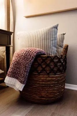 a wicker chair with pillows and a blanket at Westlake Elegance - Detroit Unit 3 in Westlake
